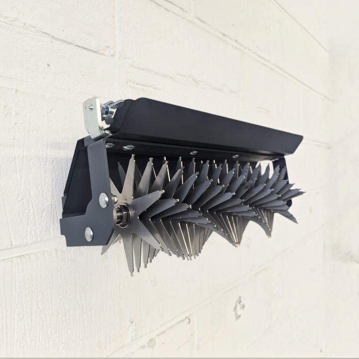 Rasenspecht Universalhalter aus Edelstahl zur Wandmontage von Gartenwerkzeugen an einer weißen Ziegelwand
